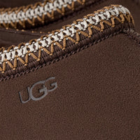 Close-up of a brown UGG product with braided trim