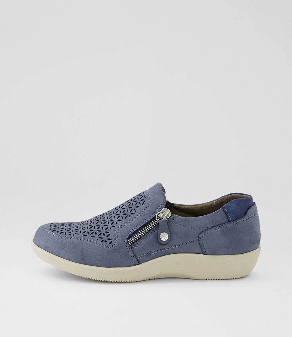 A single slip-on wedge shoe in slate blue suede with a geometric cutout pattern on the toe, a side zipper, and a cream-colored sole, shown against a light gray background.