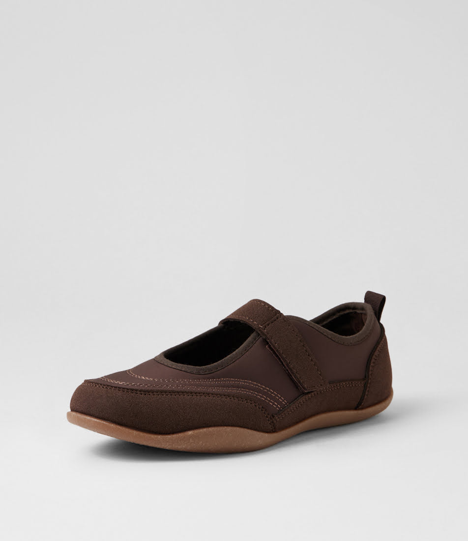 A dark brown slip-on shoe with a hook-and-loop strap across the top and a pull tab at the heel, shown from a side profile on a light gray background.